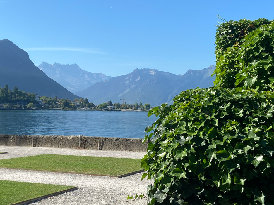 A serene park area next to Castle Chillon Montreux, offering a splendid view of Lake Geneva.