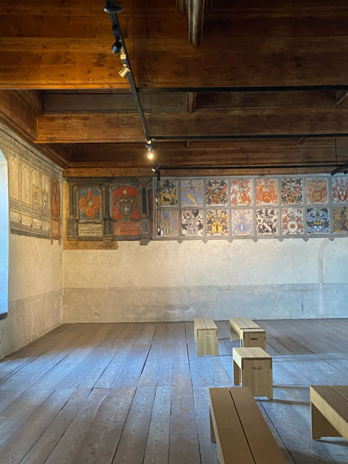 An interior view of Chillon Castle Montreux, revealing a historic room with mural paintings.