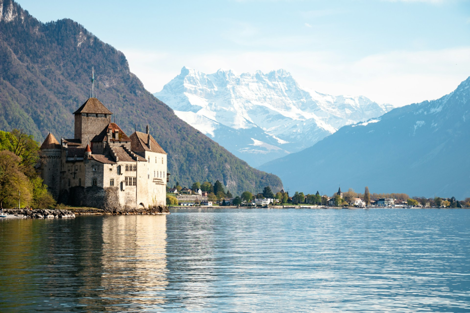 Chillon Castle with the dramatic snow-capped Alps in the background, creating a postcard-perfect alpine view.