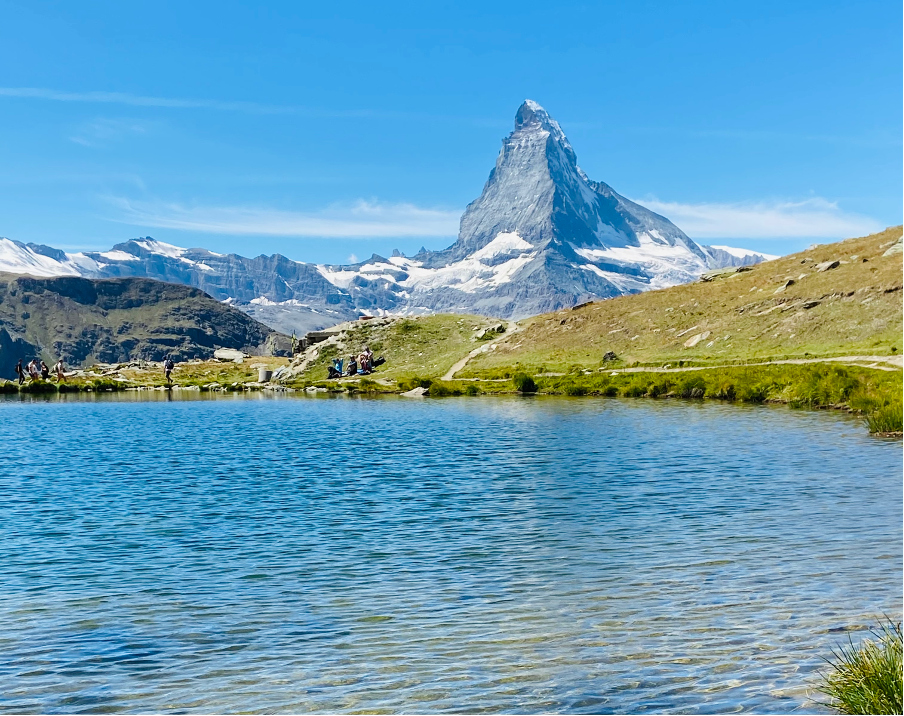 A serene view of Stellisee, located in Zermatt, a car-free mountain resort in Switzerland, on a clear day, with the iconic Matterhorn rising in the background.