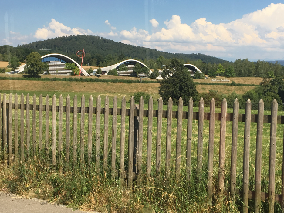 A scenic view of the Paul Klee Museum in Bern, showcasing its iconic wave-like architecture surrounded by lush greenery, highlighting one of the best museums of