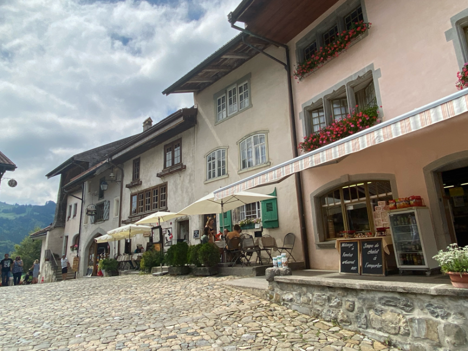 A scenic view of the hilltop town of Gruyères, one of Switzerland's most beautiful villages, with stunning views and well-preserved medieval buildings.