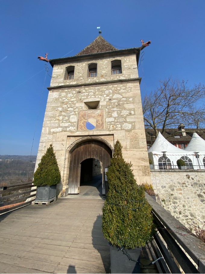 Entrance to Laufen Castle on a sunny day, showcasing its historic architecture and inviting visitors to explore its rich past.