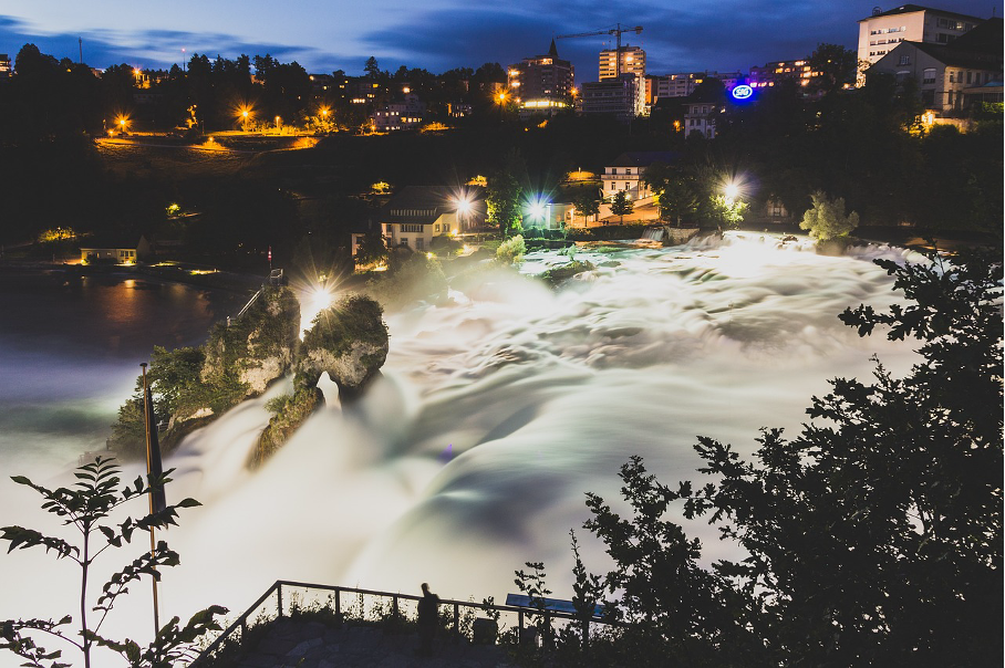 Rhine Falls illuminated at night, showcasing the stunning beauty of Switzerland’s natural wonder.