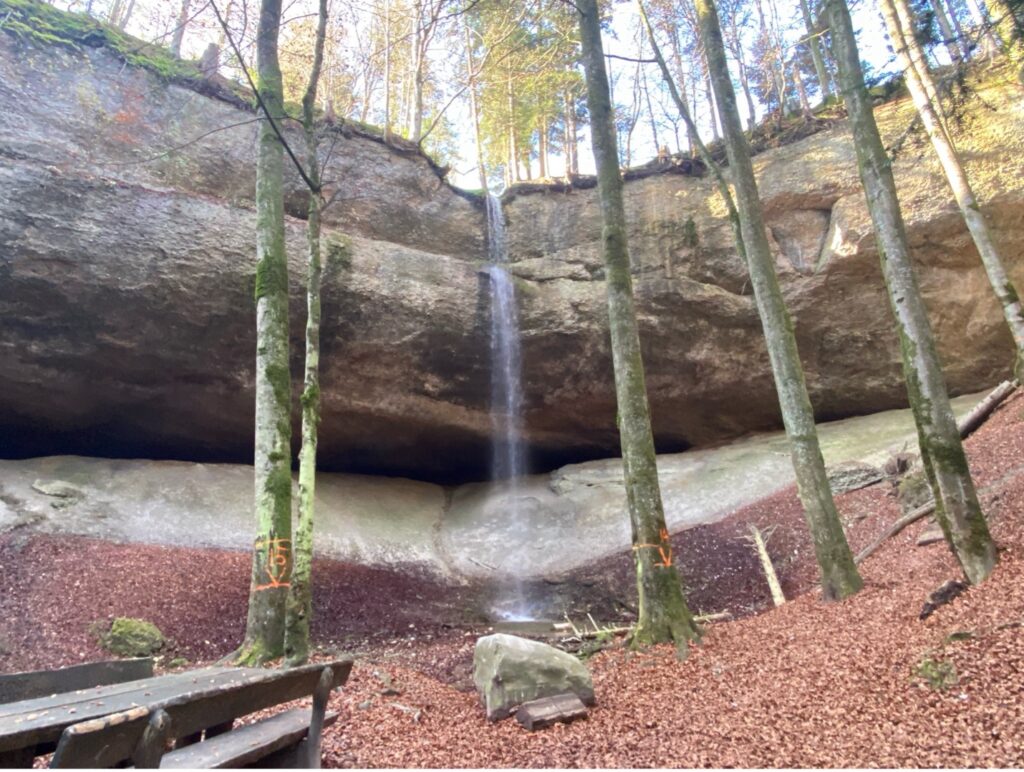 The Wissengubel Waterfall cascading over rocks, a perfect nature escape along the Bachtel Mountain hiking trail.