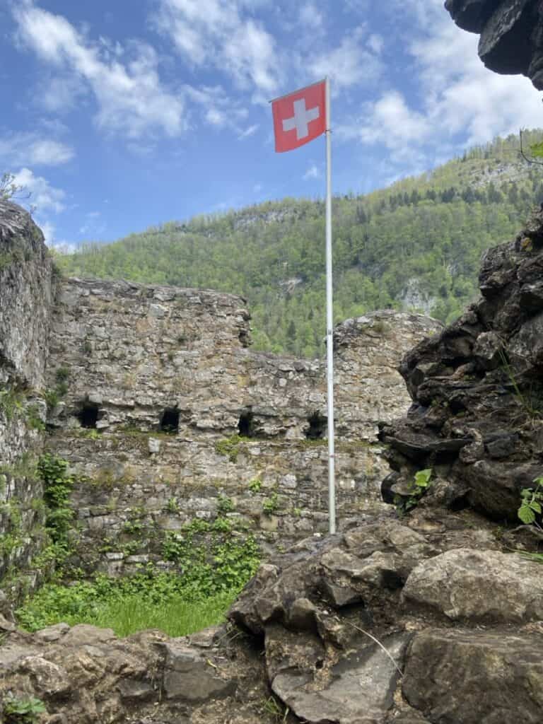 Close view of medieval Strahlegg castle ruins near Betlis with Swiss flag. 