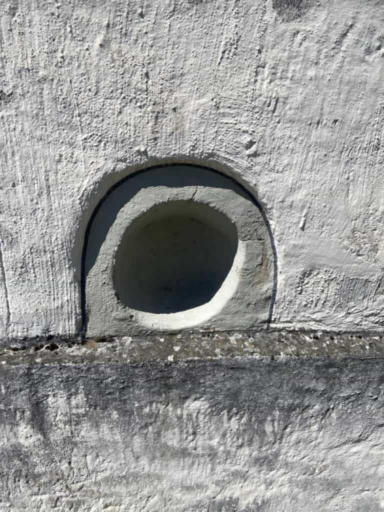 Kopfwehloch (headache hole) in wall at Büelkirche Chapel in Weesen, Switzerland