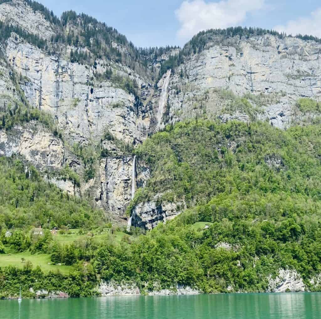 Powerful Seerenbach Falls cascading down cliffs above Lake Walensee