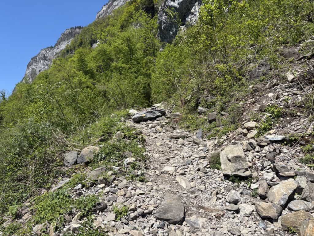 Steep rocky hiking trail descending toward Quinten above Lake Walensee