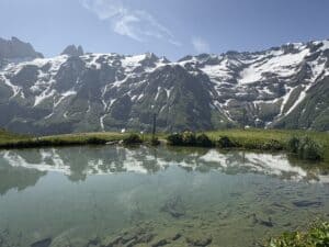 Spiegelseeli (Mirror Lake) on Fürenalp with snow-covered peaks reflected in the water, part of one of the easy hikes in Switzerland and a perfect day trip from Zurich.