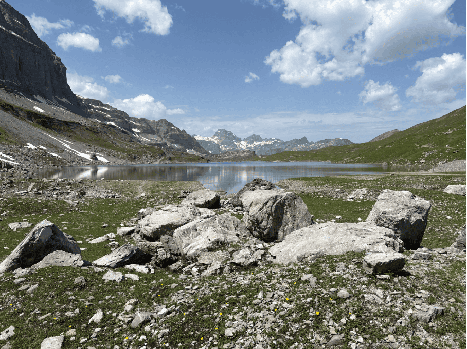 Rocky shore of Glattalpsee, hidden mountain lake surrounded by the Swiss Alps