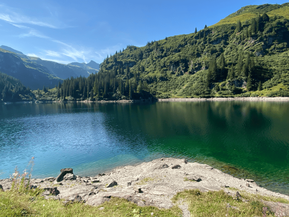 Turquoise-green Garichti Lake on Mettmenalp surrounded by trees and mountains, perfect day trip from Zurich