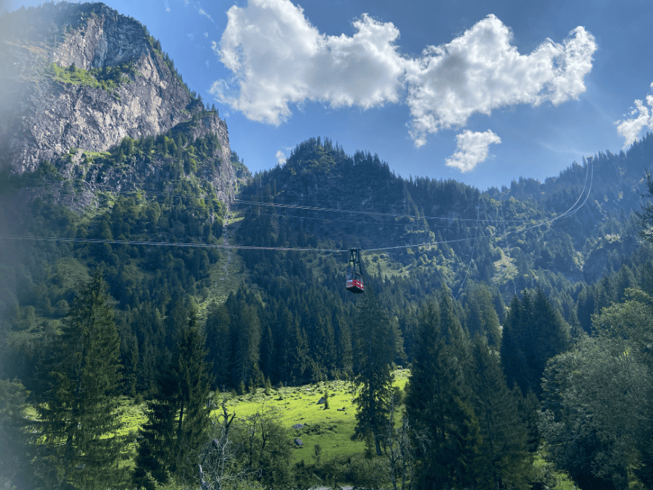 Small red Mettmenalp Garichti Lake cable car gliding down