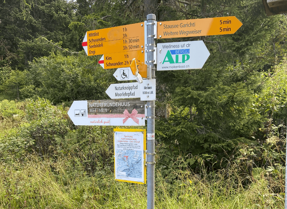 Hiking signpost on Mettmenalp giving directions to trails and Garichti Lake
