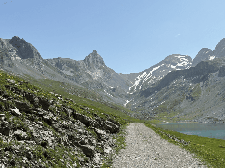 Wide gravel road along Glattalpsee, a hidden Swiss mountain lake in Central Switzerland.