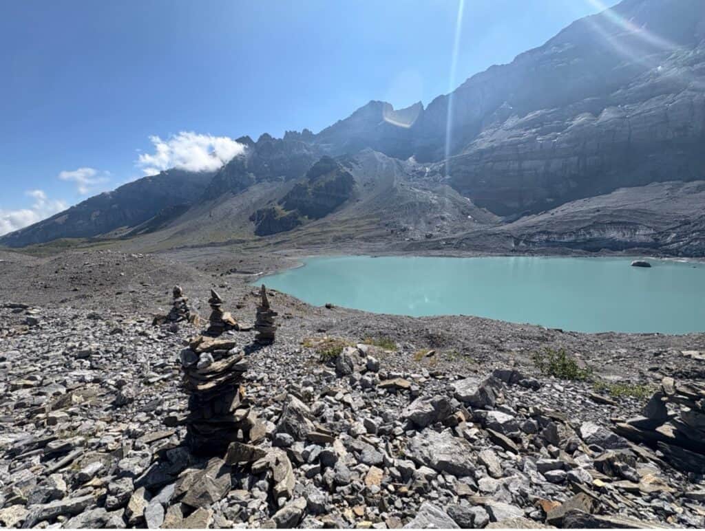 Gletscherseeli glacier lake with rocky surroundings and small stone formations built by hikers.