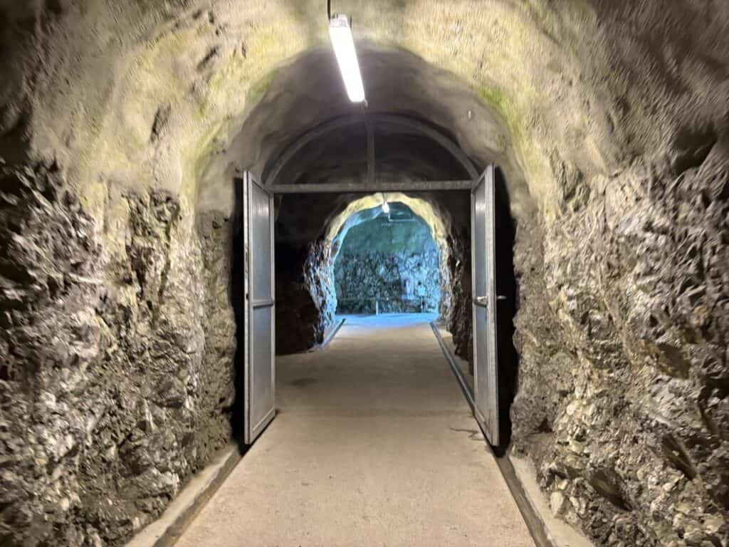 Rock tunnel leading toward the Stockhorn viewing platform, with natural stone walls forming a narrow passageway.