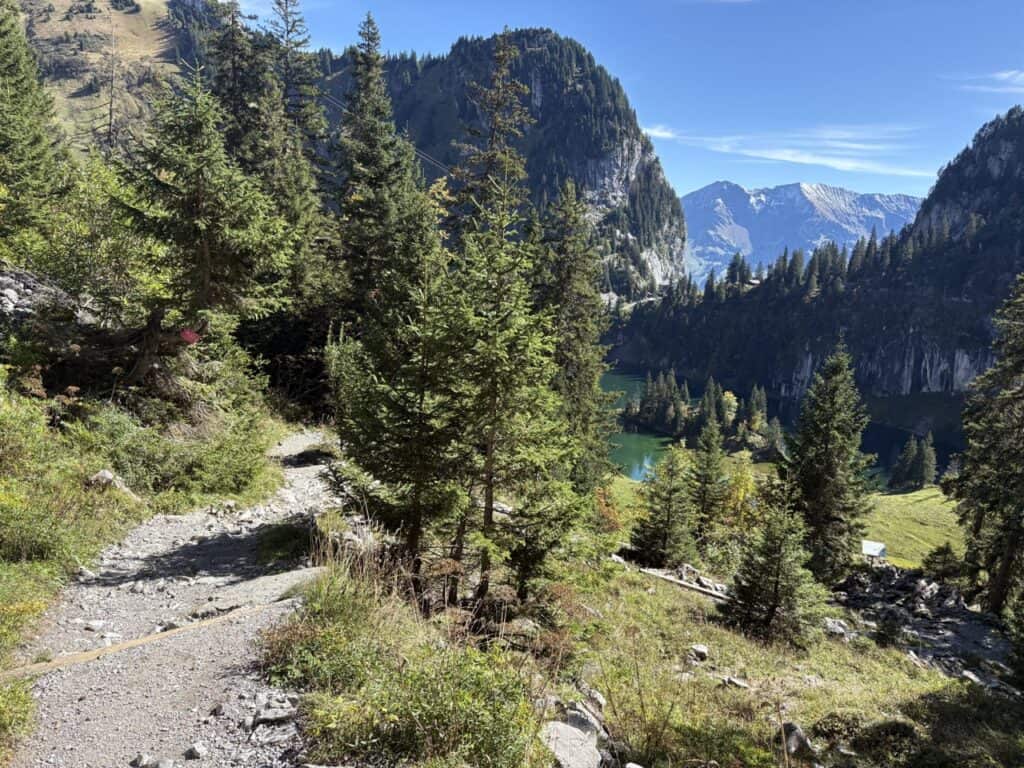 Hiking trail descending from Oberstockenalp to the crystal-clear Hinterstockensee lake.