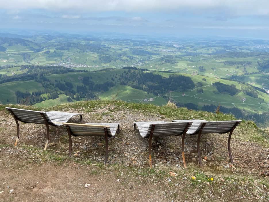 Wooden lounge chairs at the Kronberg summit inviting hikers to rest and enjoy the view