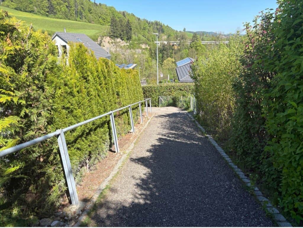 Walking path through a quiet residential neighborhood leading down to the Äulischlucht