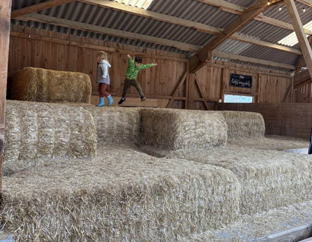 Children playing on large hay bales at Jucker Farm in Seegräben, a family-friendly stop along the Lake Pfäffikon circular walk.