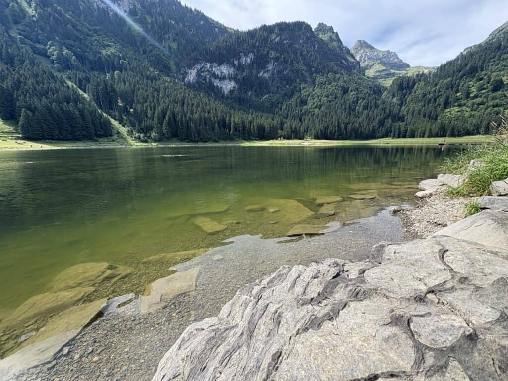 Rocky shore of Voralpsee, a beautiful Swiss mountain lake surrounded by alpine peaks. 