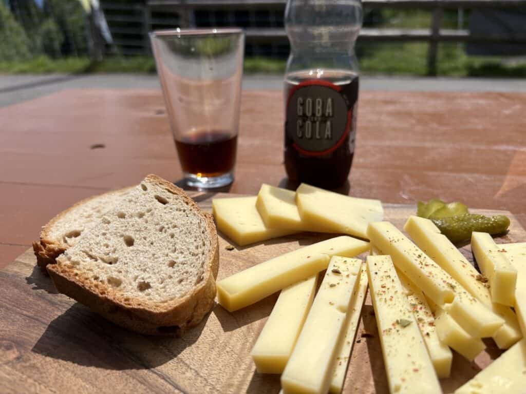 Platter with cheese, fresh bread, pickles, and a Gobi Cola enjoyed at the Alpsennerei Höhi-Voralp, a cheese dairy.  