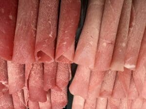 Frozen thinly sliced rolled veal and chicken for Fondue Chinoise, a Swiss meat fondue