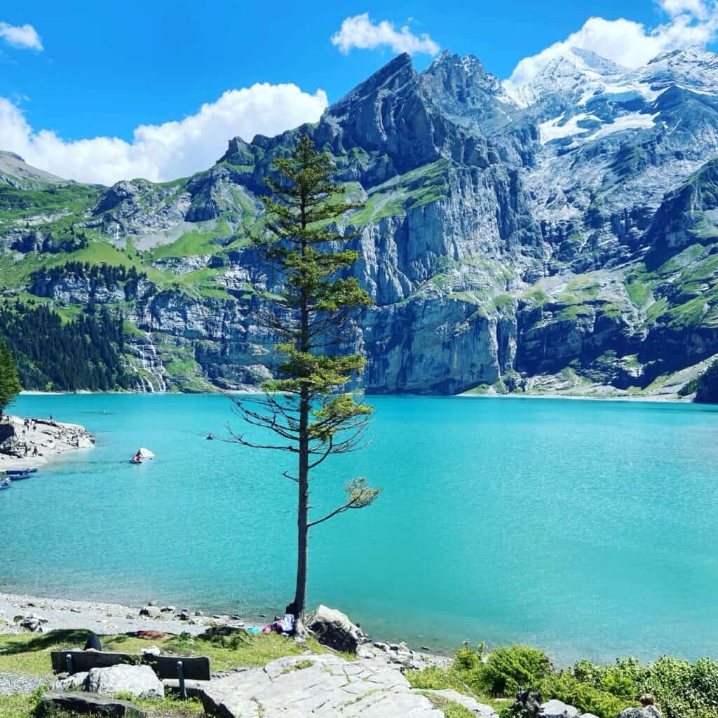 Oeschinensee with turquoise water surrounded by towering rock walls above Kandersteg in the Bernese Oberland, Switzerland.