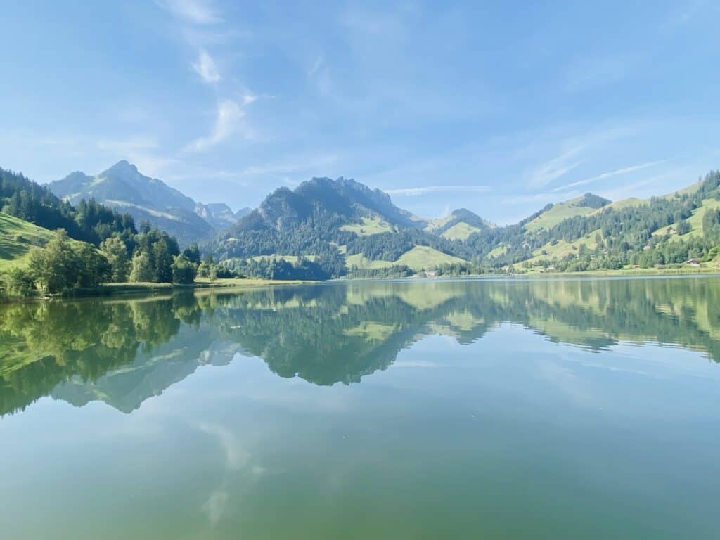 Schwarzsee in the canton of Fribourg, a peaceful mountain lake with clear water surrounded by alpine pastures and the Pre-Alps.