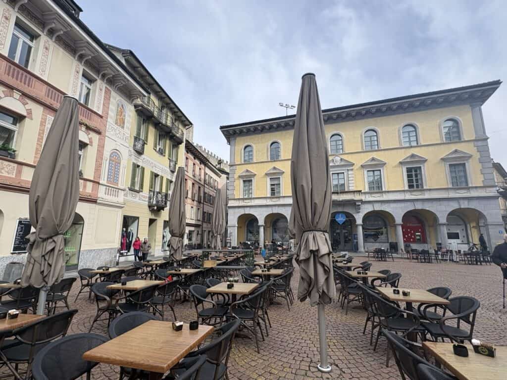 Charming square in Bellinzona Old Town with cafes and historic facades.
