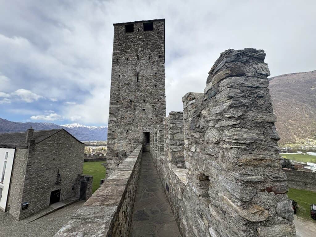 Massive tower of Castel Grande Castle standing quiet against the blue-grey sky.