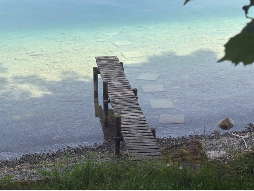 Wooden jetty leading into the turquoise blue waters of Lake Aegeri .