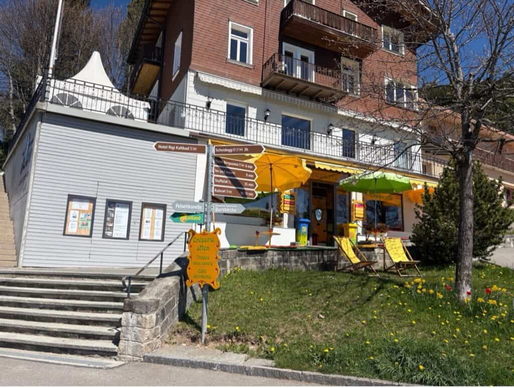Creperie restaurant in traditional chalet-type house at Rigi Kaltbad with yellow sun chairs. 