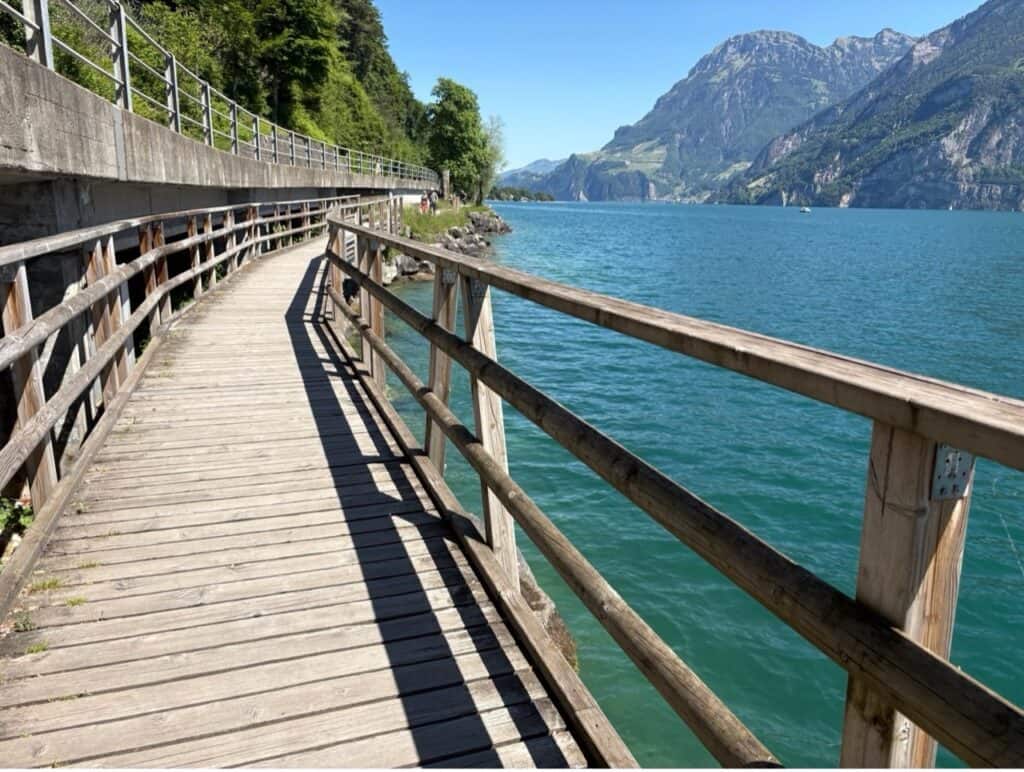 A sturdy wooden boardwalk pedestrian path along Lake Lucerne.
