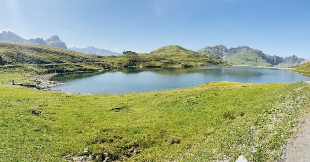 Beautiful Tannensee reservoir near Melchsee-Frutt, surrounded by green alpine meadows and mountains.
