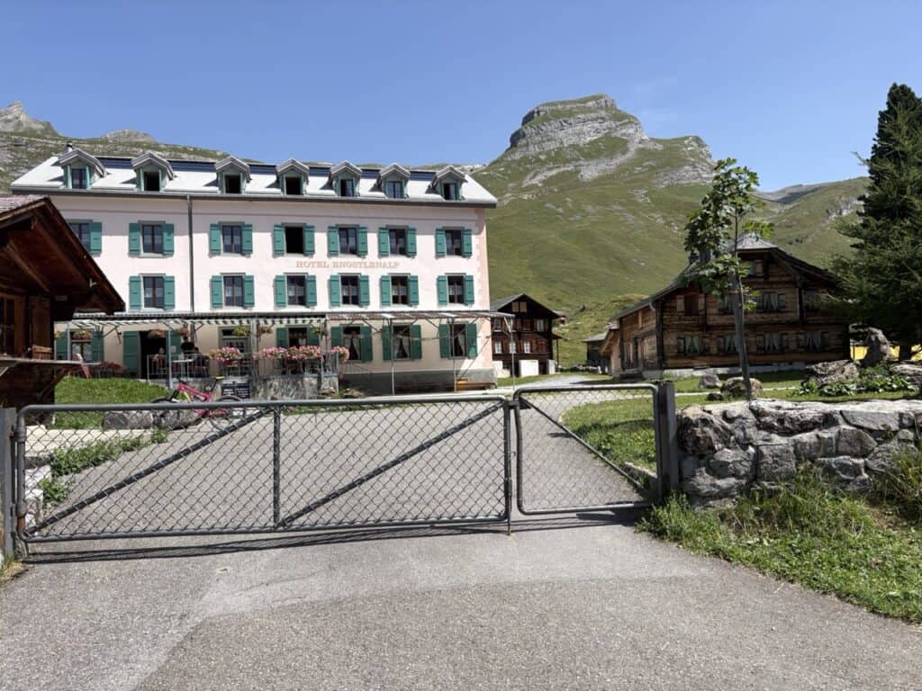 Traditional Hotel Engstlenalp nestled in a beautiful alpine landscape, a welcoming stop along the Four Lakes Hike in Switzerland.
