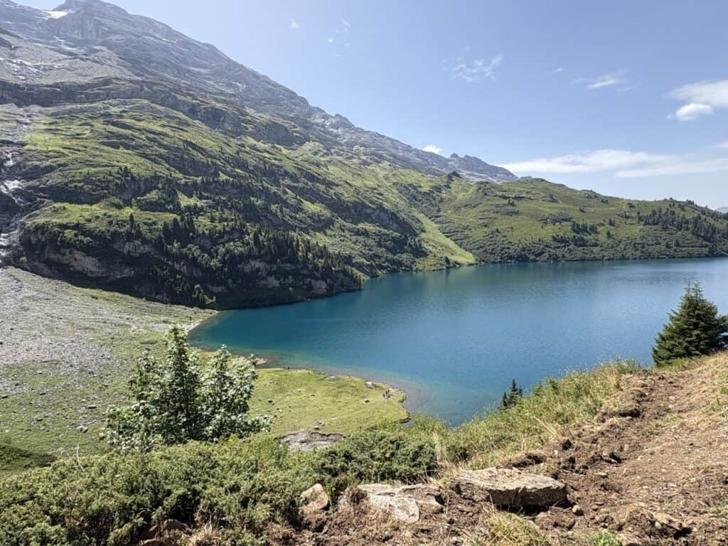 Breathtaking view of turquoise Engstlensee from the hiking trail ascending towards Jochpass, with spectacular Swiss Alpine scenery.
