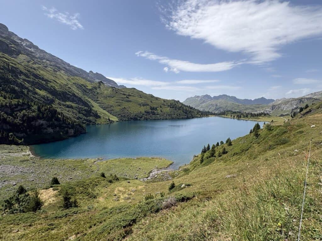 Breathtaking view of turquoise Engstlensee from the hiking trail ascending towards Jochpass, with spectacular Swiss Alpine scenery.